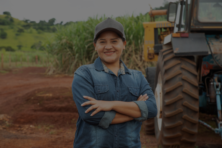 farmer with arms crossed in front of tractor